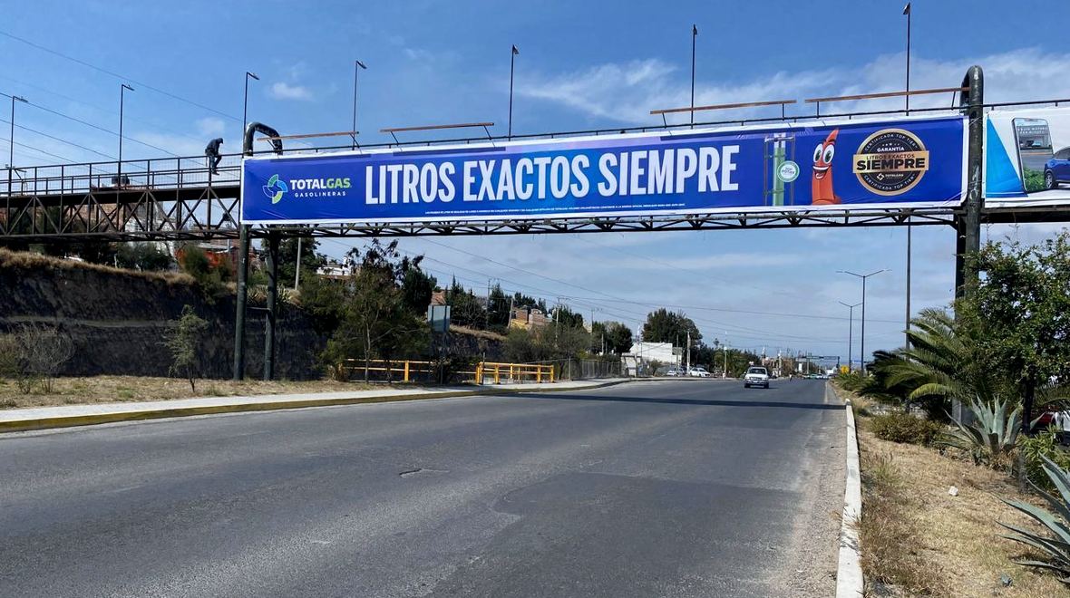 Publicidad en puente peatonal sobre una avenida de San Miguel de Allende